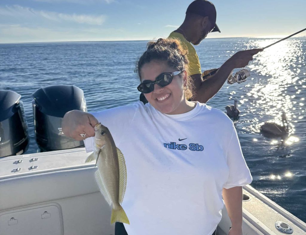 Beginner angler catches first fish on a family fishing charter with Coast To Coast Sport Fishing In San Diego